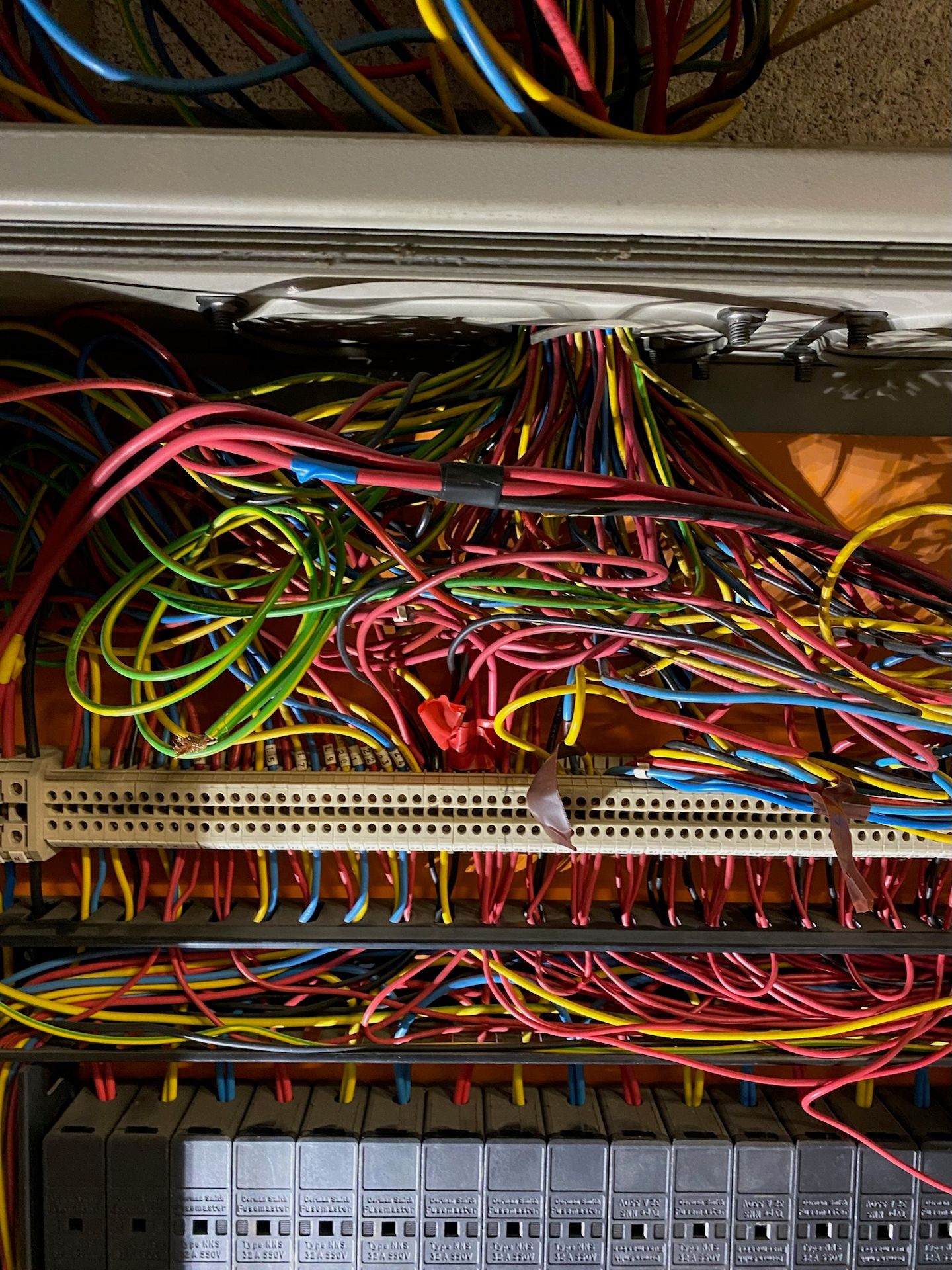 Close-up view of a complex electrical panel with numerous colorful wires connected to various terminals and components.